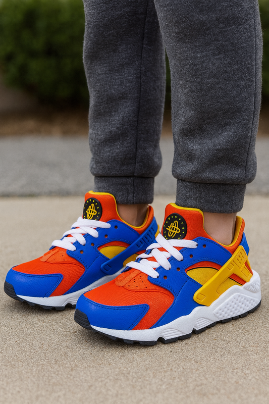 Colorful sneakers with orange, blue, and yellow design worn by a person in gray pants.